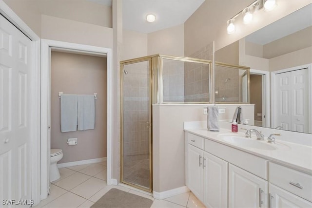 bathroom with vanity, toilet, a shower with door, and tile patterned flooring