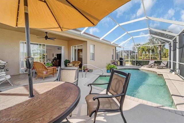 view of pool featuring a patio, ceiling fan, and glass enclosure