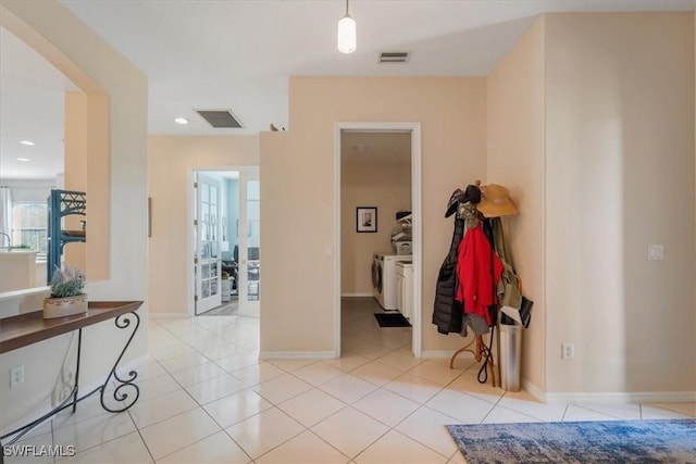 entryway featuring light tile patterned flooring and separate washer and dryer