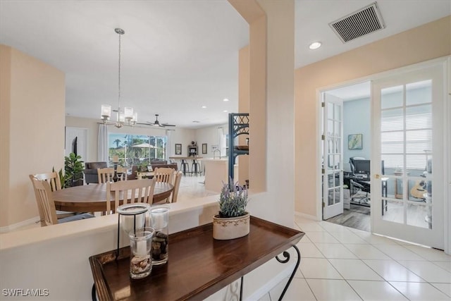 dining area with french doors, an inviting chandelier, and light tile patterned floors