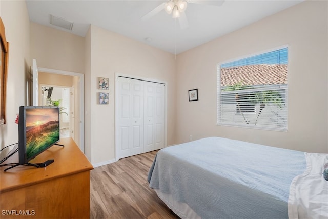 bedroom with light hardwood / wood-style flooring, a closet, and ceiling fan