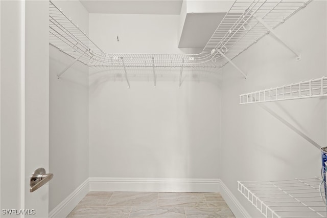 walk in closet with marble finish floor