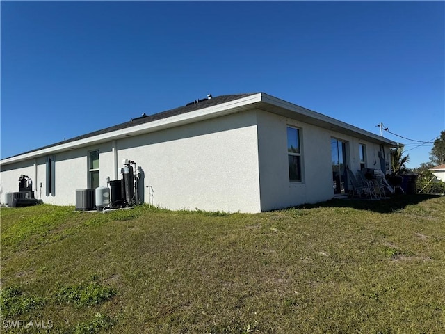 view of side of home with central air condition unit and a lawn