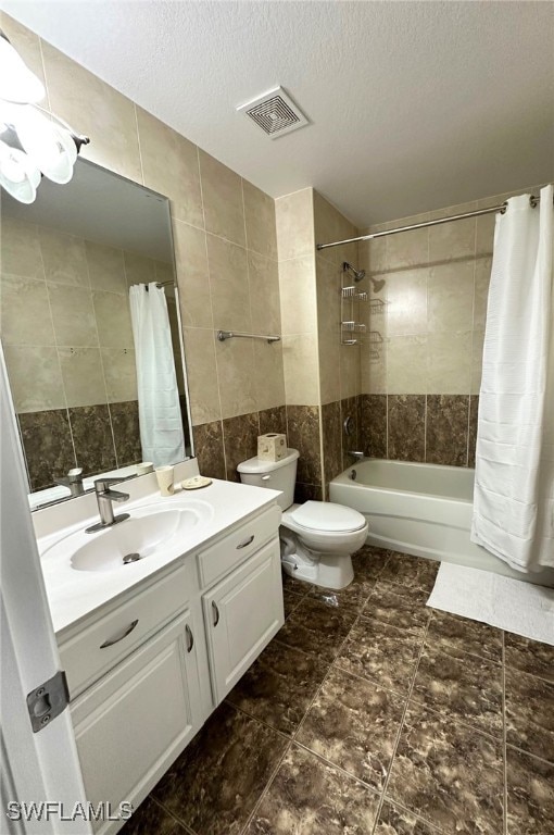 full bathroom with shower / bathtub combination with curtain, tile walls, vanity, a textured ceiling, and toilet