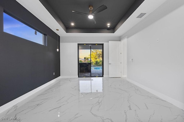 spare room featuring ceiling fan and a tray ceiling