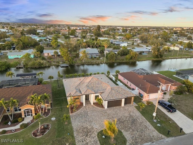 aerial view at dusk featuring a water view