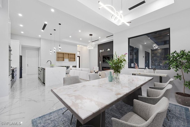 dining space with sink and a tray ceiling