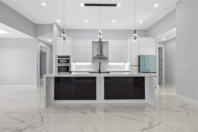 kitchen featuring wall chimney range hood, white cabinets, double oven, and decorative light fixtures