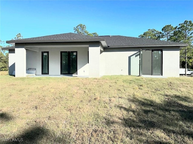 rear view of property with a yard