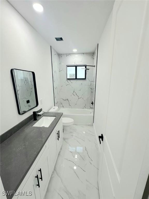 full bathroom featuring tiled shower / bath, vanity, and toilet