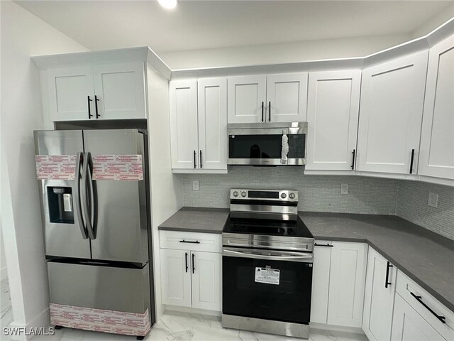 kitchen with tasteful backsplash, white cabinetry, and stainless steel appliances