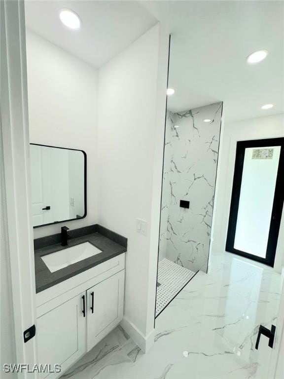 bathroom with vanity and a tile shower