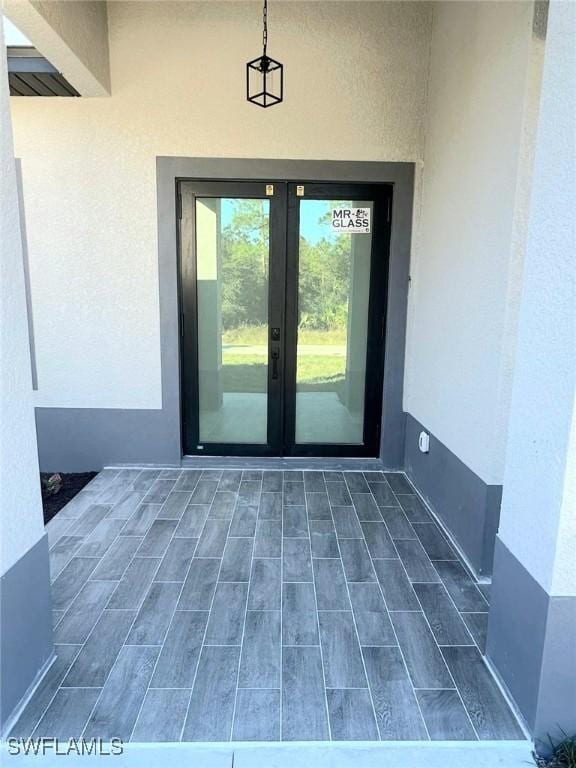 view of exterior entry with french doors and stucco siding