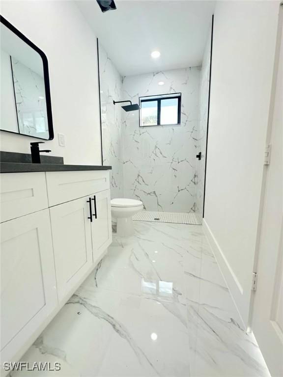 bathroom with toilet, marble finish floor, recessed lighting, a marble finish shower, and vanity