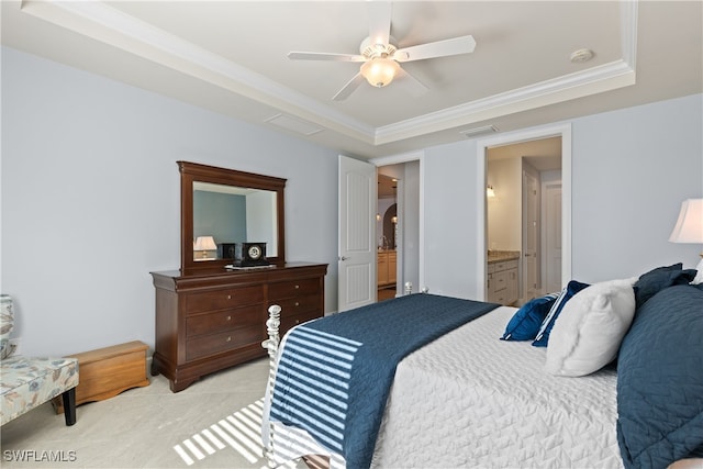 bedroom with ceiling fan, connected bathroom, a tray ceiling, ornamental molding, and light carpet