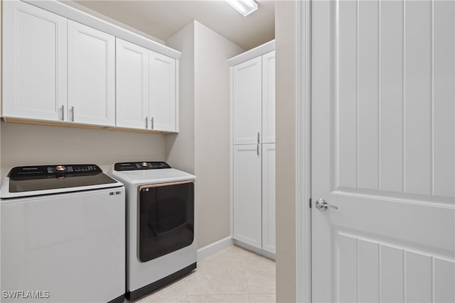 clothes washing area featuring cabinets, independent washer and dryer, and light tile patterned floors