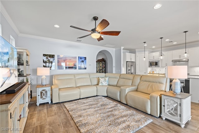 living room with ornamental molding, sink, ceiling fan, and light hardwood / wood-style floors