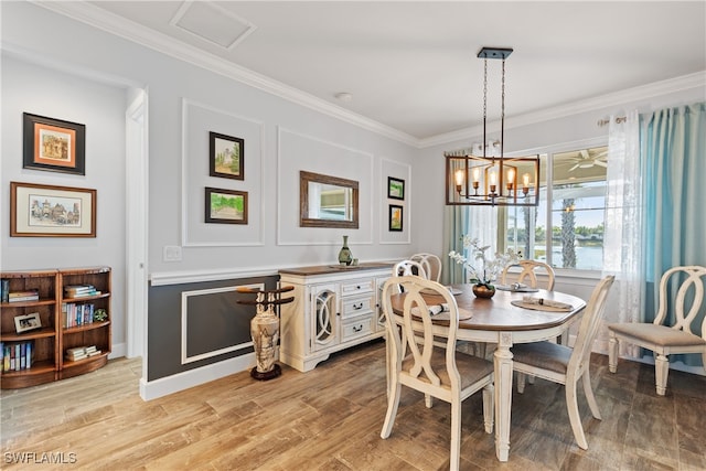 dining space featuring crown molding, a chandelier, and light wood-type flooring