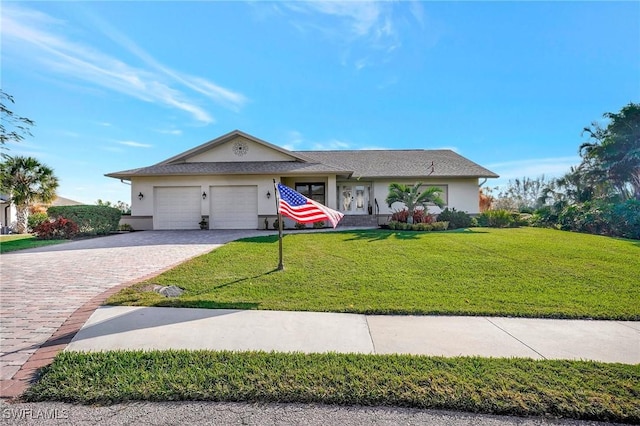 ranch-style home featuring an attached garage, decorative driveway, a front yard, and stucco siding