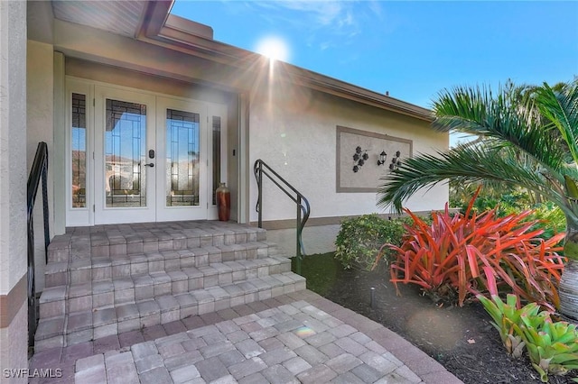 doorway to property featuring french doors and stucco siding