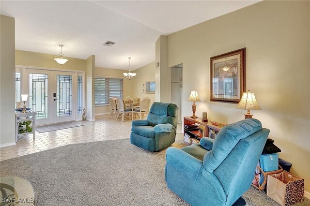 living area with light tile patterned floors, lofted ceiling, light colored carpet, visible vents, and french doors