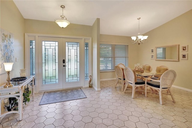 entryway featuring french doors, a notable chandelier, light tile patterned flooring, vaulted ceiling, and baseboards