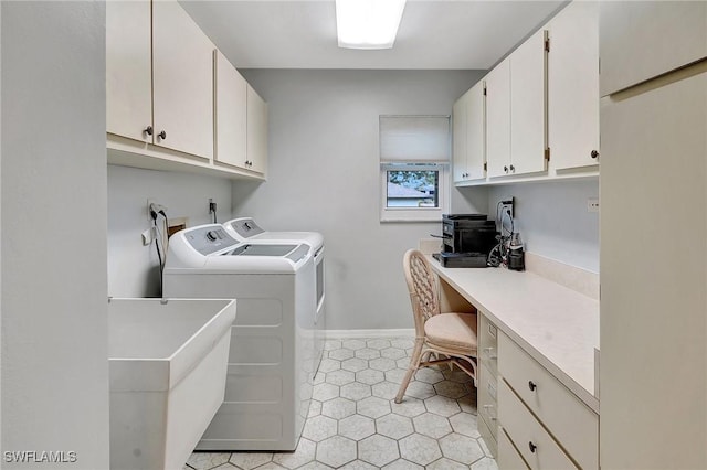 clothes washing area with cabinet space, light tile patterned floors, baseboards, washing machine and clothes dryer, and a sink