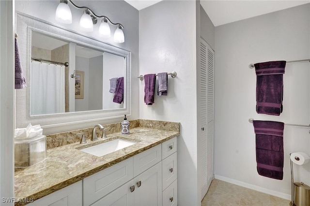 full bathroom featuring a closet, vanity, and baseboards