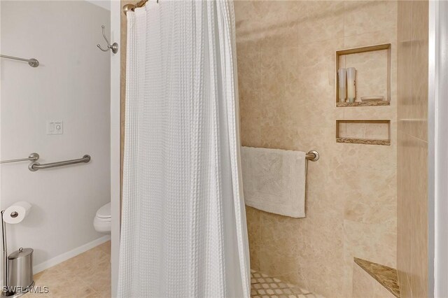 bathroom with a shower stall and baseboards