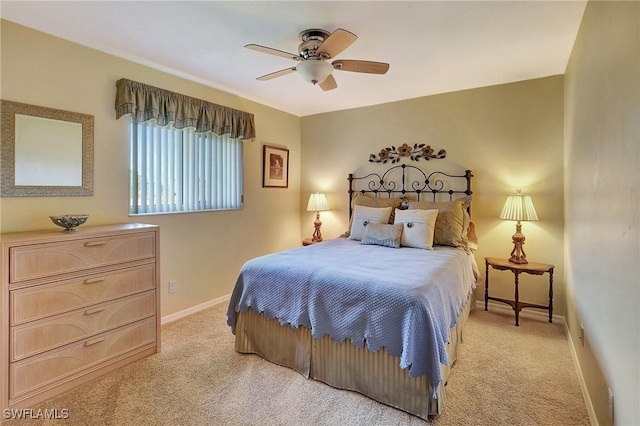 bedroom featuring a ceiling fan, light colored carpet, and baseboards