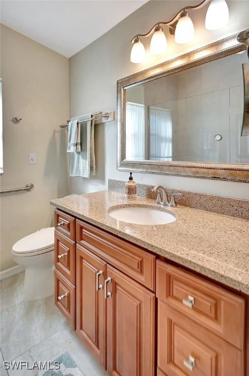 bathroom featuring tile patterned flooring, vanity, and toilet