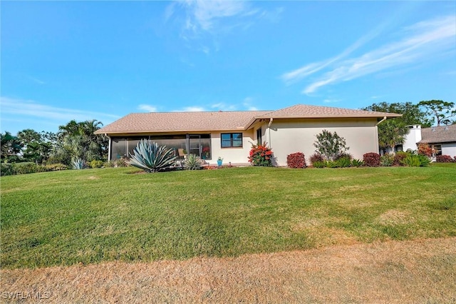 ranch-style house featuring stucco siding and a front yard