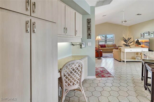 kitchen featuring lofted ceiling, light countertops, visible vents, open floor plan, and ceiling fan