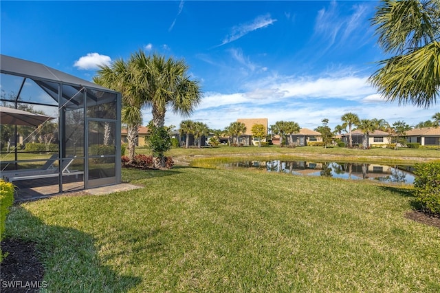 view of yard with a lanai and a water view