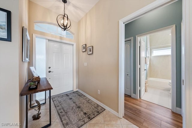 entryway with light tile patterned floors and a notable chandelier