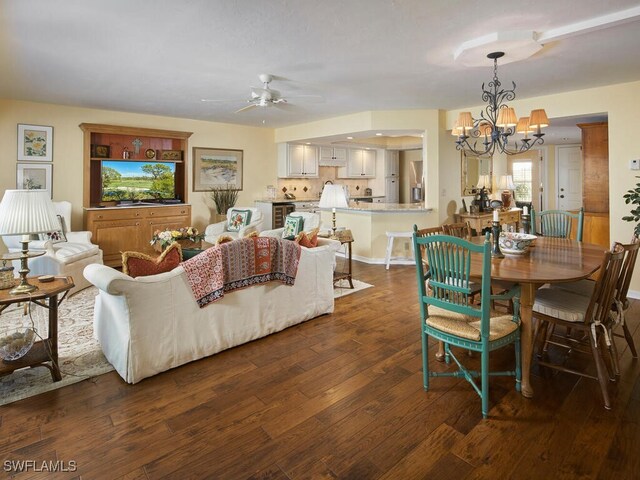 dining space with dark hardwood / wood-style floors and ceiling fan with notable chandelier