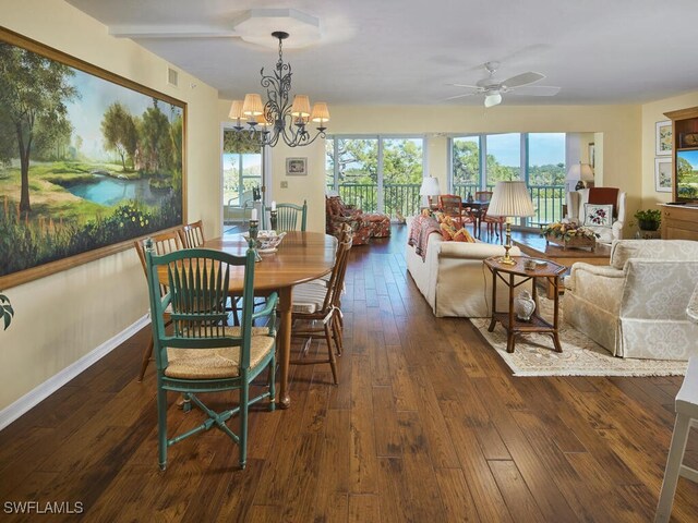 dining space with hardwood / wood-style flooring, ceiling fan with notable chandelier, visible vents, and baseboards