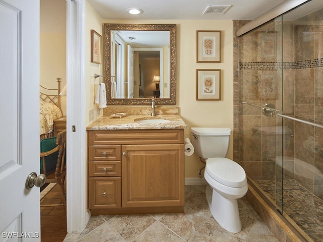 bathroom with a shower with door, vanity, and toilet