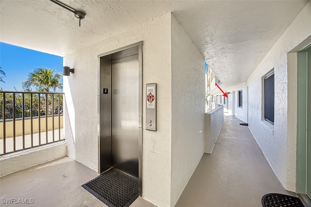 property entrance featuring elevator and a balcony