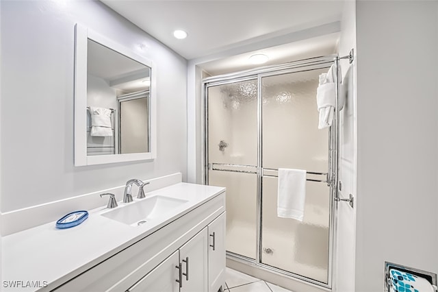 bathroom with vanity, a shower with shower door, and tile patterned flooring