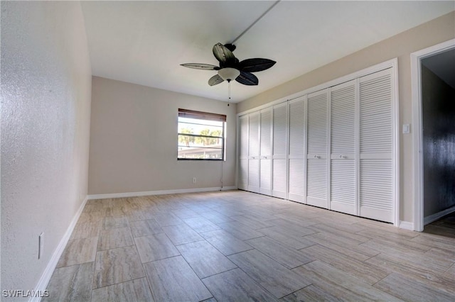 unfurnished bedroom with ceiling fan and a closet