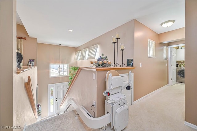 rec room with washer / dryer, a towering ceiling, and light carpet