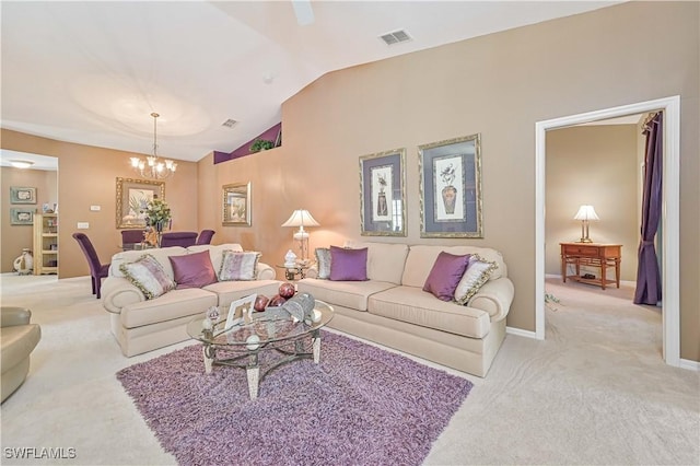 carpeted living room featuring a chandelier and vaulted ceiling