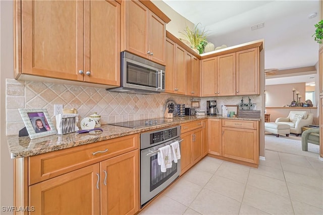 kitchen with light stone counters, stainless steel appliances, decorative backsplash, and light tile patterned floors