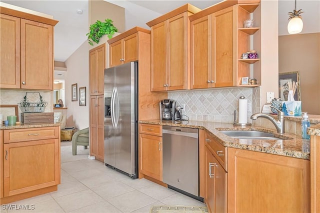 kitchen featuring sink, light tile patterned floors, appliances with stainless steel finishes, backsplash, and light stone counters