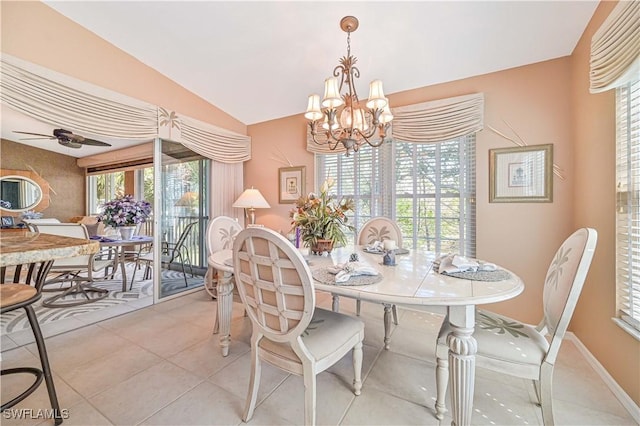 dining area featuring light tile patterned flooring, lofted ceiling, and ceiling fan with notable chandelier