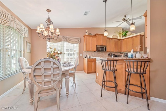 kitchen featuring tasteful backsplash, pendant lighting, plenty of natural light, and kitchen peninsula