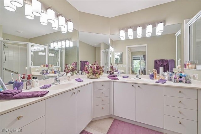 bathroom featuring vanity, a shower with shower door, and tile patterned flooring