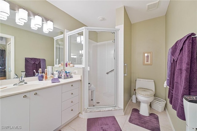 bathroom with tile patterned flooring, vanity, an enclosed shower, and toilet