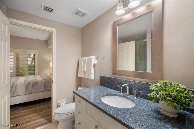 bathroom featuring vanity, hardwood / wood-style flooring, and toilet